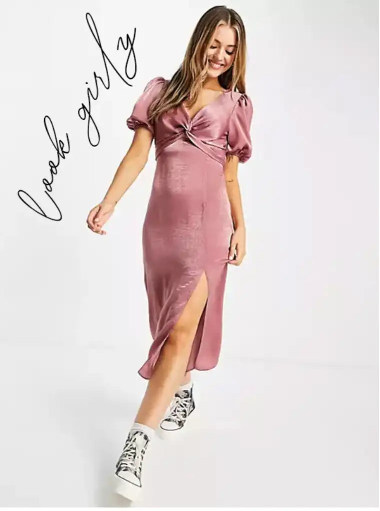 Une robe midi en satin rose poussière avec un bustier torsadé et des manches courtes bouffantes, dotée d'une fente haut de jambe.