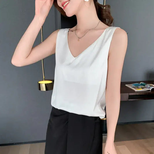 Débardeur femme en satin soyeux blanc à bretelles fines, style chic et élégant, porté avec un jean – idéal pour un look estival tendance.