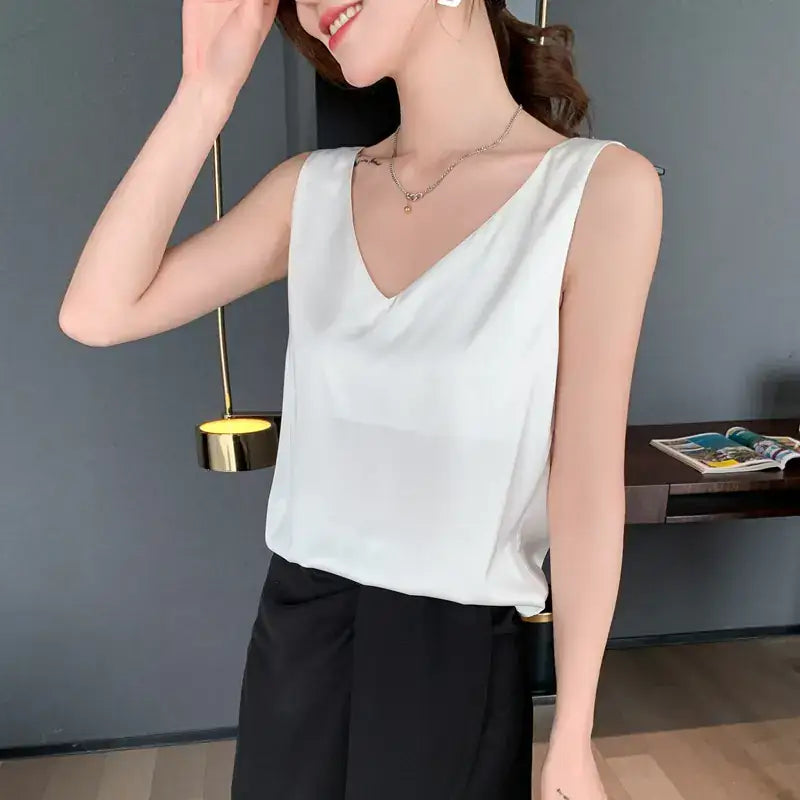 Débardeur femme en satin soyeux blanc à bretelles fines, style chic et élégant, porté avec un jean – idéal pour un look estival tendance.