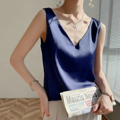 Débardeur femme en satin soyeux bleu marine à bretelles fines, style chic et élégant, porté avec un jean – idéal pour un look estival tendance.
