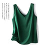 Débardeur femme en satin soyeux vert foncé à bretelles fines, style chic et élégant, porté avec un jean – idéal pour un look estival tendance.