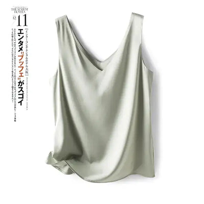 Débardeur femme en satin soyeux vert haricot à bretelles fines, style chic et élégant, porté avec un jean – idéal pour un look estival tendance.