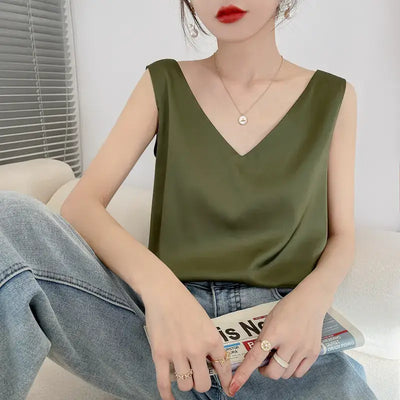 Débardeur femme en satin soyeux vert kaki à bretelles fines, style chic et élégant, porté avec un jean – idéal pour un look estival tendance.