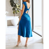 Femme portant une robe de soirée en satin à manches courtes, couleur bleue, dos nu avec nœud torsadé, coupe moulante flatteuse – look chic et élégant pour l’été.