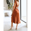 Femme portant une robe de soirée en satin à manches courtes, couleur brune, dos nu avec nœud torsadé, coupe moulante flatteuse – look chic et élégant pour l’été.