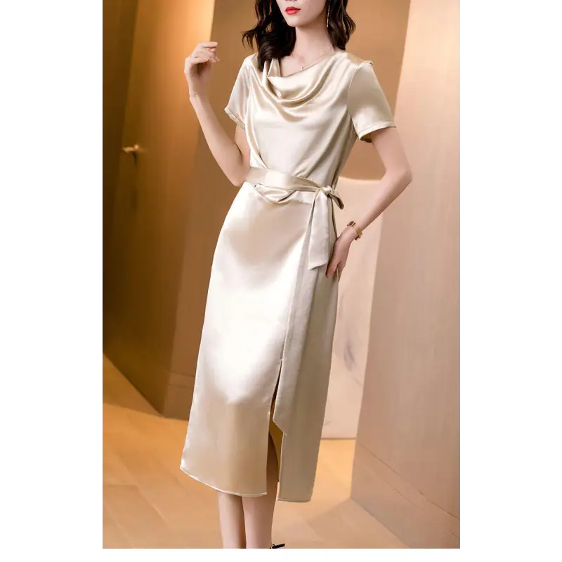 Femme portant une robe en satin de soie mûrier, cintrée à la taille, en couleur Champagne, au tombé fluide et élégant pour l’été.