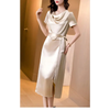 Femme portant une robe en satin de soie mûrier, cintrée à la taille, en couleur Champagne, au tombé fluide et élégant pour l’été.