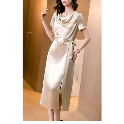 Femme portant une robe en satin de soie mûrier, cintrée à la taille, en couleur Champagne, au tombé fluide et élégant pour l’été.