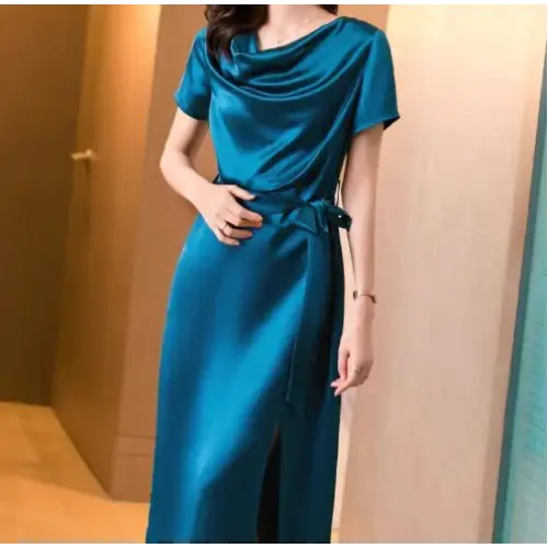 Femme portant une robe en satin de soie mûrier, cintrée à la taille, en couleur Bleu Paon, au tombé fluide et élégant pour l’été.
