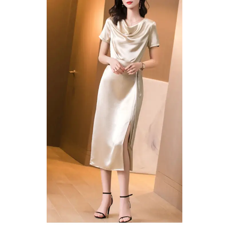 Femme portant une robe en satin de soie mûrier, cintrée à la taille, en couleur Champagne, au tombé fluide et élégant pour l’été.