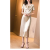 Femme portant une robe en satin de soie mûrier, cintrée à la taille, en couleur Champagne, au tombé fluide et élégant pour l’été.