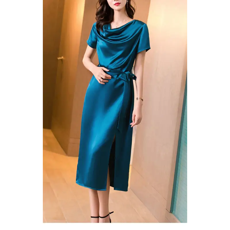 Femme portant une robe en satin de soie mûrier, cintrée à la taille, en couleur Bleu Paon, au tombé fluide et élégant pour l’été.
