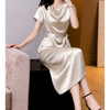 Femme portant une robe en satin de soie mûrier, cintrée à la taille, en couleur Champagne, au tombé fluide et élégant pour l’été.