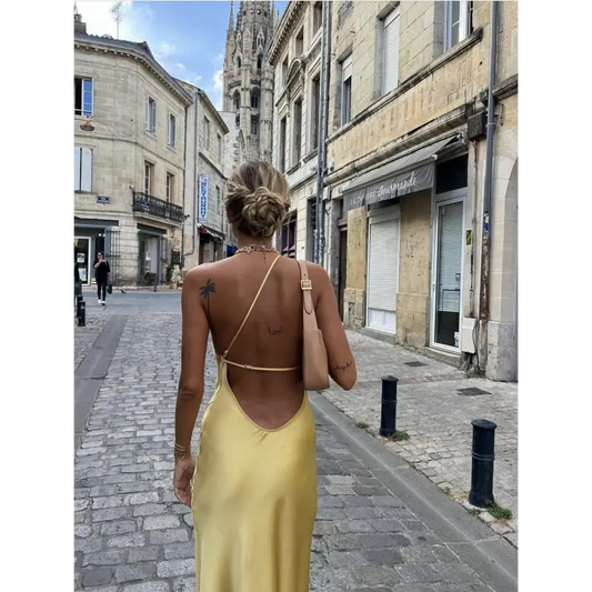 Femme portant une robe longue en satin jaune avec fente latérale et épaule dénudée