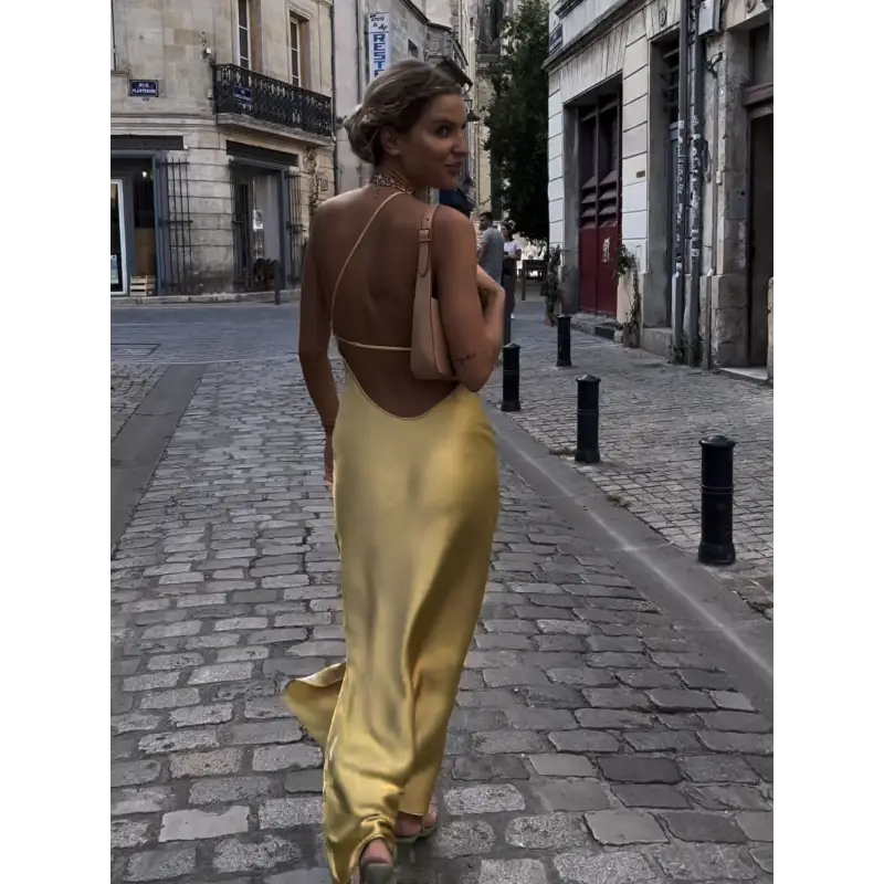 Femme portant une robe longue en satin jaune avec fente latérale et épaule dénudée