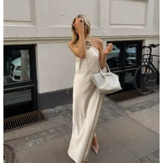 Femme portant la Robe Satin Santorini Champagne, longue et fluide, idéale pour soirée élégante

