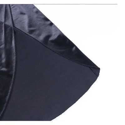 Robe noire satinée sexy à bretelles fines avec fente latérale, élégante et fluide, parfaite pour une soirée chic ou un événement formel.