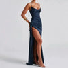 Femme portant une robe satinée bleu marine à dos nu et fente haute, silhouette élégante et sensuelle pour une soirée chic.